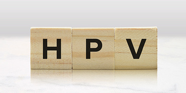 Drei Buchstaben-Plättchen bilden die Abkürzung HPV für Humane Papillomviren