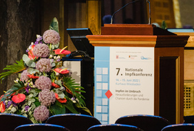 Saal mit leeren Stuhlreihen und Blick auf Rednerpult, 7. Nationale Impfkonferenz